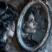 Une femme avec un air mélancolique se reflétant dans un miroir, évoquant la Mort dans les Contes de Fées et les Mythes