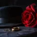 Un chapeau Fedora noir, des anneaux dorés et une rose rouge composent une scène qui évoque les rites funéraires de la mafia, alliant élégance et symbolisme solennel.