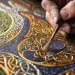 Artisan peignant avec précision des motifs celtiques complexes en référence au style historique du Livre de Durrow.