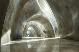 Un espace intérieur du cimetière souterrain en Israël, présentant des arches imposantes et des jeux de lumière qui créent une ambiance sereine et sacrée.