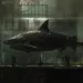 Un gigantesque requin conservé dans un aquarium, exposé dans une salle remplie de squelettes humains, une scène artistique qui rappelle les œuvres de Damien Hirst et leur exploration de la mortalité.