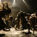 Scène de théâtre où des danseurs interprètent une chorégraphie dramatique autour du thème "Mort et scène", évoquant l'idée de memento-mori à travers leurs gestes intenses et désordonnés.