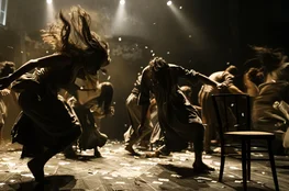 Scène de théâtre où des danseurs interprètent une chorégraphie dramatique autour du thème "Mort et scène", évoquant l'idée de memento-mori à travers leurs gestes intenses et désordonnés.