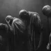 Image en noir et blanc représentant une procession d’humains voûtés, symbolisant la peur de la mort et l’idée du Memento-mori.