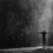 Illustration en noir et blanc d’une silhouette cruciforme face à une lumière éclatante. L’image évoque le message originel de Jésus et la méditation Memento-mori, rappelant la mort comme passage et non comme fin.