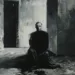 Peinture expressionniste représentant les morts-vivants du quotidien, une silhouette humaine immobile dans un couloir sombre — visuel pour Memento-mori.