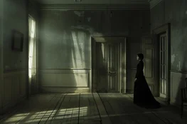 Intérieur sombre et silencieux inspiré de The Others, illustrant une vision Memento-mori de la mort comme piège et persistance, dans une maison figée hors du temps.