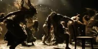 Scène de théâtre où des danseurs interprètent une chorégraphie dramatique autour du thème "Mort et scène", évoquant l'idée de memento-mori à travers leurs gestes intenses et désordonnés.