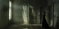 Intérieur sombre et silencieux inspiré de The Others, illustrant une vision Memento-mori de la mort comme piège et persistance, dans une maison figée hors du temps.