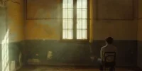 Un homme assis seul dans une pièce vide et usée par le temps, éclairée par une fenêtre, illustrant The Man from Earth dans une atmosphère Memento-mori, entre immortalité, mémoire et finitude.